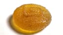 A single sugar-coated amber gummy on a white background